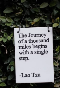 Sign with quote "The journey of a thousand miles begins with a single step." -Lao Tzu