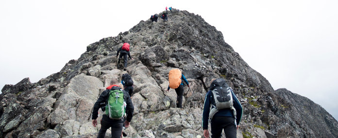 climbers hiking through mountain peak during daytime